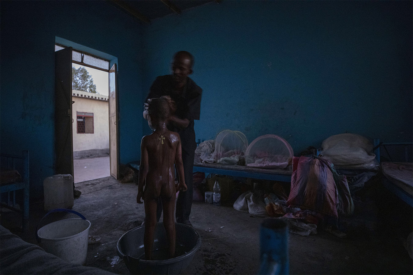 הפליט הטיגרי אברה קינף גאברמריאם, 40, מקלח את בנו בן ה-5 מישל, אחרי השכמה מוקדמת במחסה הזמני שלהם בחמדיאת, מזרח סודן, ליד הגבול עם אתיופיה. לפני חודשים אחדים התרחשה מלחמת אזרחים באתיופיה, במהלכה טיגרים רבים הפכו לפליטים. (AP Photo/Nariman El-Mofty)