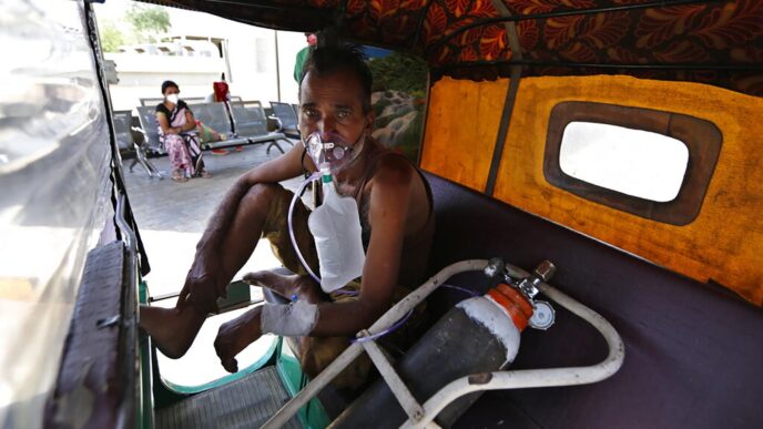 חולה קורונה ממתין בריקשה לאשפוז במרכז לחולי קורונה באחמאדבאד, הודו. בשנה שעברה כמעט התגברה הודו על המגפה (AP Photo/Ajit Solanki)