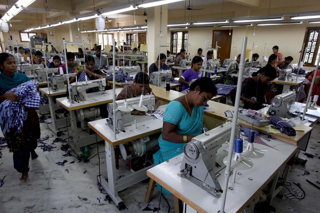 פועלות במפעל טקסטיל בהודו. הדו"ח מזהיר מהבדלים שיש למשבר בין קבוצות עובדים ומדינות שונות סביב לעולם (AP Photo/Mahesh Kumar A)