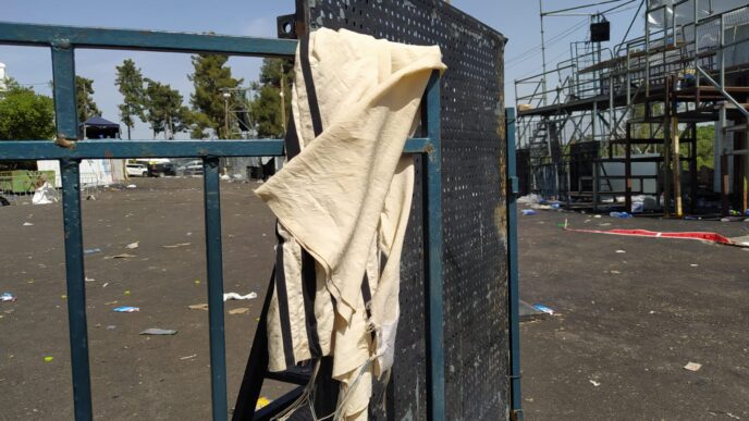 A tallit remains on a fence at Mount Meron, at the site of the tragic accident (Photo: Yahel Faraj)