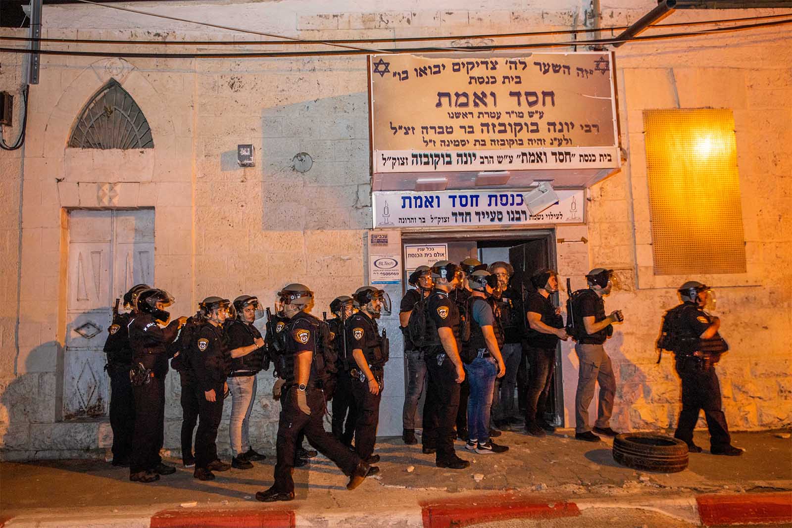 שוטרים מאבטחים את בית הכנסת 'חסד ואמת' ברמלה שהושחת במהלך הפגנות אלימות בעיר (צילום: יוסי אלוני/פלאש90)