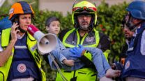 כוחות ביטחון מפנים פצוע לאחר פגיעת רקטה בבניין באשקלון (צילום: פלאש90)