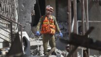 חייל צה"ל במוקד פגיעת רקטה ישירה באשקלון (צילום: AP Photo/Ariel Schalit)