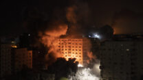 תקיפה של בניין רב קומות בעזה הלילה (צילום: AP Photo/Khalil Hamra)