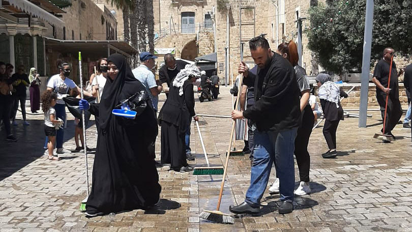 Arab and Jewish residents of Akko cleaning the streets after a night of arson and riots (Photo: Zo Haderech)