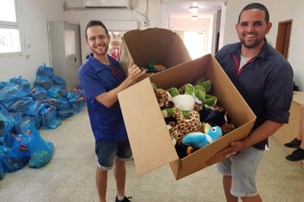 יואב רהב ויניב פסקל מכינים ערכות צעצועים לחלוקה במקלטים (צילום: אלבום פרטי)