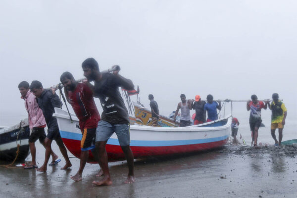 דייגים בהודו גוררים סירת דיג לחוף לקראת סופה טרופית באזור (צילום: AP Photo/Rafiq Maqbool)