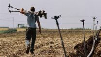 חקלאי ישראלי מחבר ממטרות בשדה (צילום אילוסטרציה: גילי יערי/פלאש90)