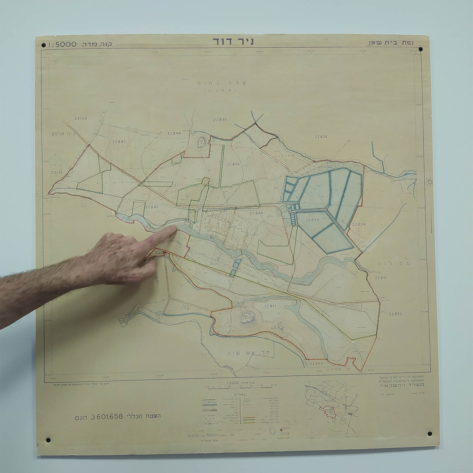 מזכיר ניר דוד, לביא מאירי, מצביע על מפה היסטורית של הקיבוץ (צילום: יהל פרג')