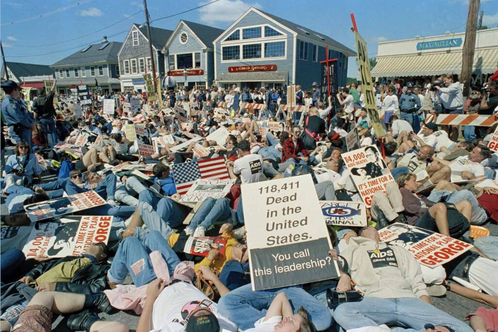 פעילי מאבק באיידס במיצג מחאתי של &quot;מוות המוני&quot; סנוך לבית הנופש של הנשיא דאז ג'ורג' בוש במדינת מיין, ארה&quot;ב, 1991. על השלט הקדמי: &quot;118,411 מתים בארה&quot;ב&quot; (AP Photo/Greg Gibson)