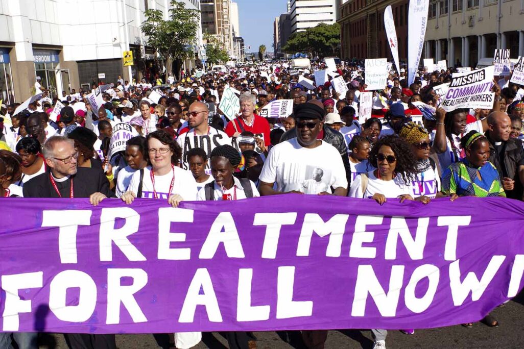 פעילי זכויות אדם מפגינים מול וועידת האיידס העולמית הראשונה בדורבן, דרום אפריקה ביולי 2016.על השלט: &quot;טיפול לכולם עכשיו!&quot; (AP Photo, File)