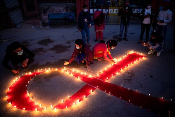 נרות בצורת סרט אדום, סמל המאבק באיידס, בטקס לציון יום האיידס הבינלאומי בבית יתומים ומרכז שיקום לנפגעי איידס בנפאל, 2020. החזרה לסיפור המגפה ההיא מטלטלת ופוקחת עיניים (Photo by Prabin Ranabhat/SOPA Images/LightRocket via Getty Images)