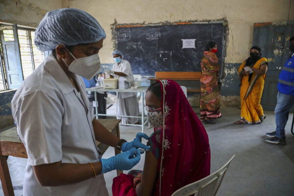 אישה מתחסנת בהודו. חלוקת חיסונים לא שוויונית מגדילה את הפערים (AP Photo/Mahesh Kumar A)