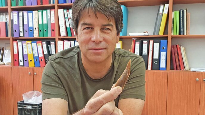 החוקר ד&quot;ר עמרי ברזילי, פרהסטוריון ברשות העתיקות מחזיק חוד מאבן צור מאתר בוקר תחתית (צילום: רשות העתיקות)