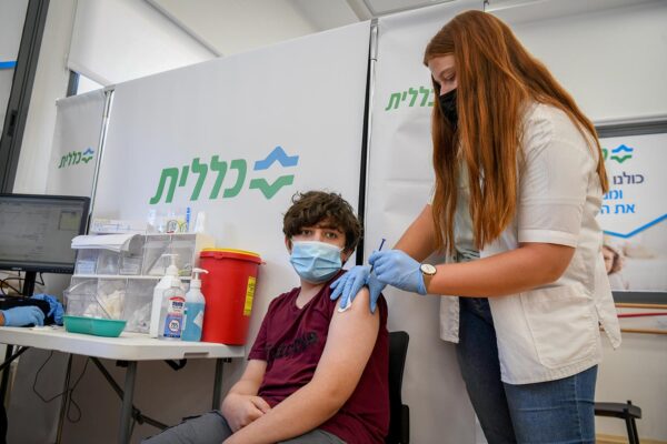 נער מקבל חיסון לקורונה במרכז החיסונים בפתח תקווה (צילום: פלאש 90)