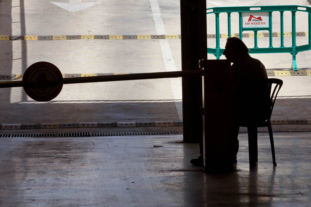 A guard sitting in the entrance to a parking lot in a shopping mall. (Photo: Moshe Shai/FLASH90)