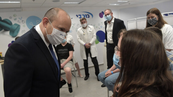 Israeli prime minister Naftali Bennett with teens at a vaccination center (Photo: Koby Gidon)