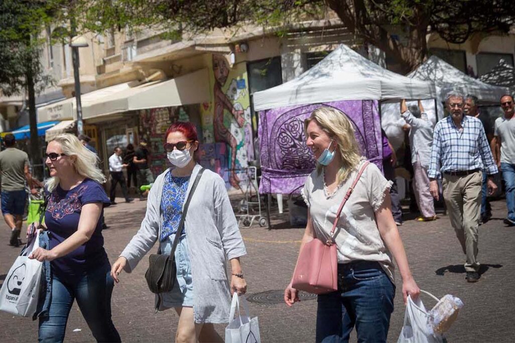 Israelis walk on the streets of Tel Aviv without wearing protective face masks. (Photo: Miriam Alster/FLASH90)