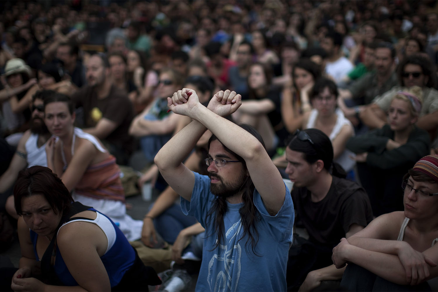 סימן ידיים של 'אי הסכמה' באספה במחאה במדריד (צילום: AP Photo/Emilio Morenatti)