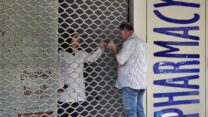 אדם מדבר עם רוקחת בבית מרקחת סגור. בתי המרקחת בלבנון שבתו בגלל מחסור חמור בתרופות יסודיות (צילום: AP Photo/Bilal Hussein, File)
