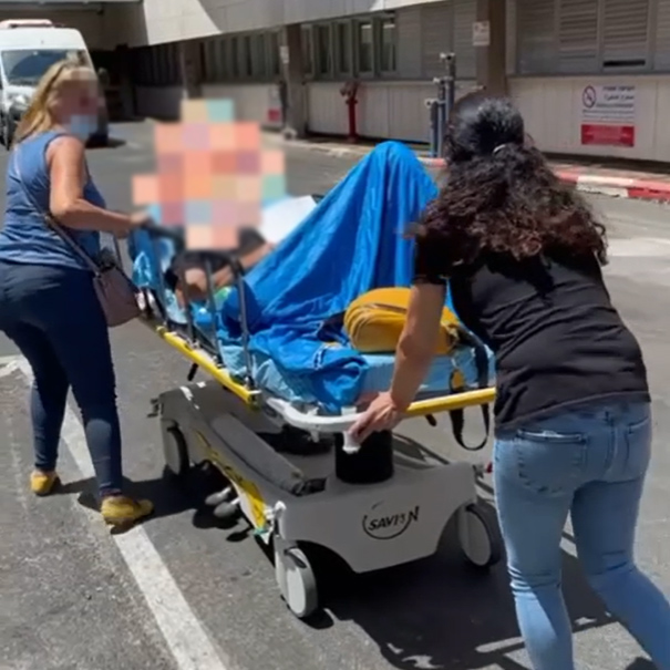 בנות משפחה של מטופל במרכז הרפואי שיבא משנעים אותו בתוך בית החולים
