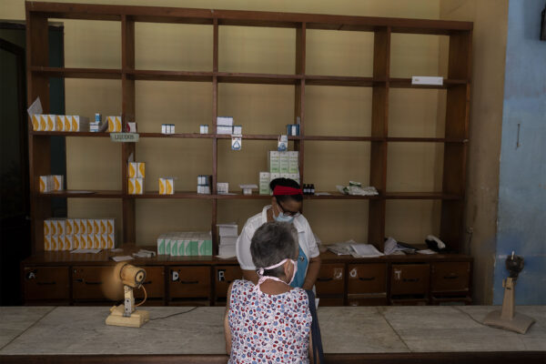 רוקחת ולקוחה בבית מרקחת בהוואנה, 15 ביולי 2021. המדינה סובלת ממחסור בתרופות בעקבות המשבר הכלכלי ומגפת הקורונה (AP Photo/Eliana Aponte)