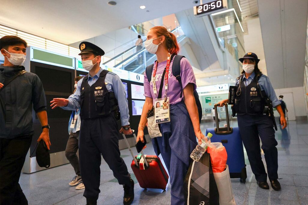 האצנית הבלארוסית, קריסטינה צימנווסקאיה, מלווה על ידי שוטרים בשדה התעופה בטוקיו (צילום: REUTERS/Issei Kato)