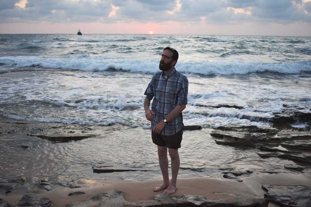 חננאל רוזן מתפלל עם הגב לים בחוף בצת. "אינסופי אבל גם סופי" (צילום: אוריאל לוי)
