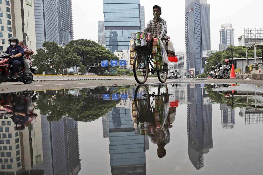 מוכר משקאות על אופניים בג'קרטה, אינדונזיה. &quot;מזרח אסיה מייצרת כמעט שליש מהתפוקה הכלכלית העולמית, אך הכלכלנים המתגוררים באזור זה אחראים לפחות מ-5% מהמאמרים בכתבי העת הגדולים&quot; (AP Photo/Dita Alangkara)