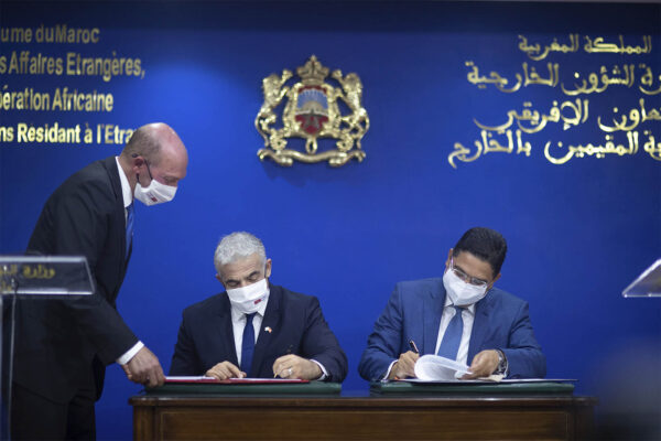 שר החוץ של מרוקו נאסר בוריטה (מימין) ושר החוץ הישראלי יאיר לפיד (משמאל) חותמים על הסכמי שיתוף פעולה בין שתי המדינות, ברבאט, מרוקו. (צילום: AP/Mosa'ab Elshamy)