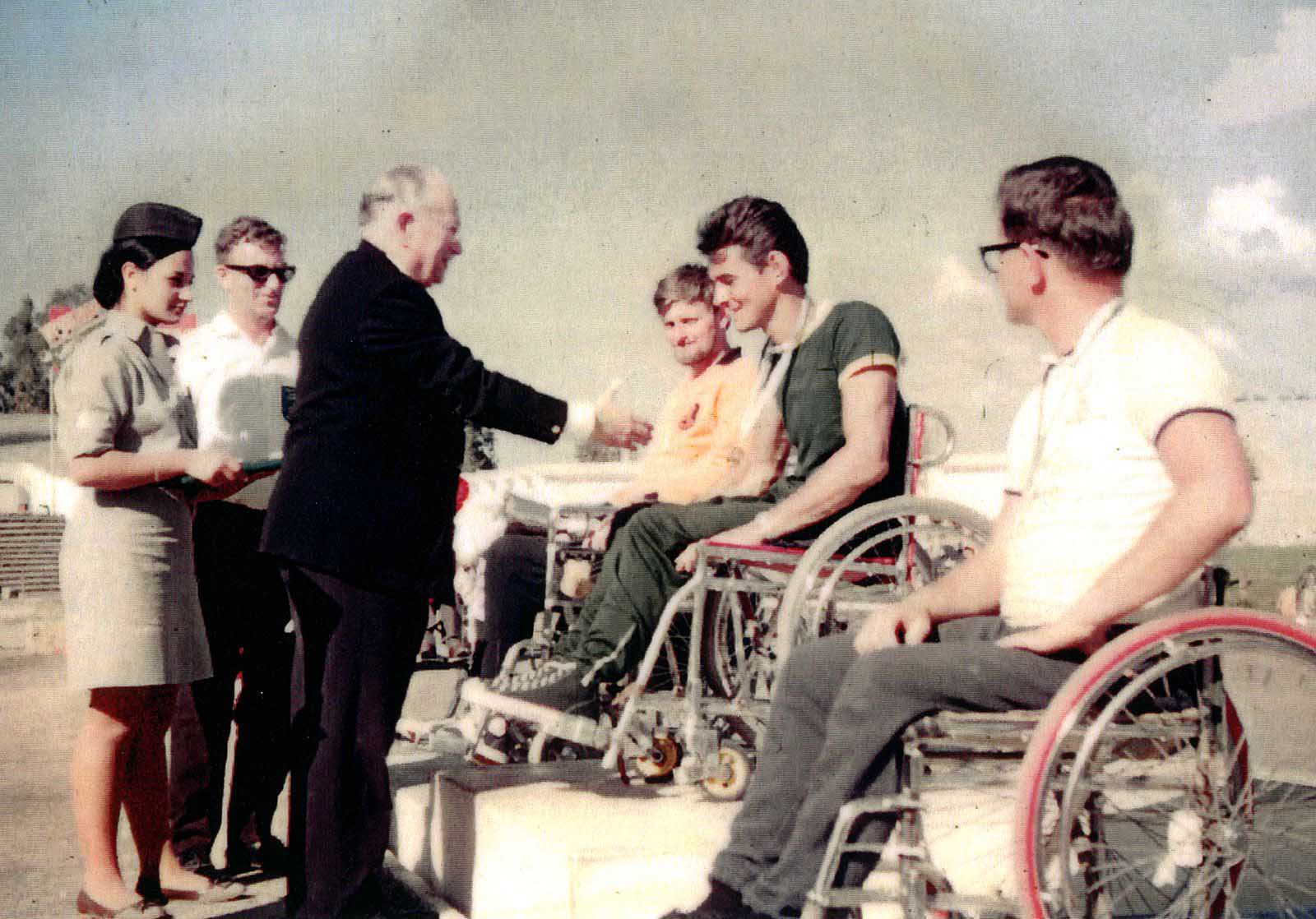 د. لودڤيچ چوتمان، مؤسس الألعاب البارالمبية، يقدّم الميدالية الذهبية خلال الألعاب البارالمبية تل أبيب 1964 (تصوير: Australian Paralympic Committee / ويكيميديا كونونس)