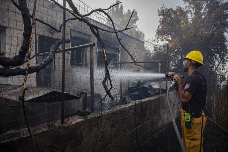 A firefighters extinguishing a fire at the moshav Giva'at Ye'arim. (Photo: Olivier Fitoussi/ Flash90)