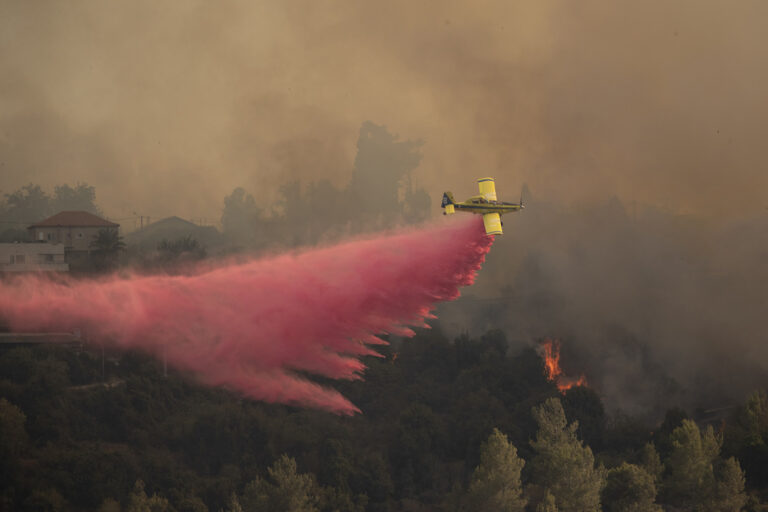 מטוס כיבוי מפזר חומר מעכב שריפות סמוך למושב שורש ביום השני של שריפת הענק בהרי ירושלים. (צילום: AP Photo/Maya Alleruzzo)