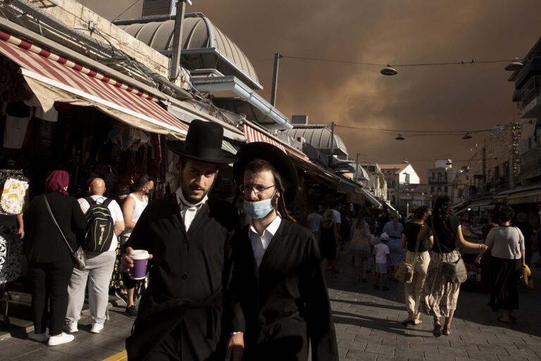 שמיים שחורים מעל שוק מחנה יהודה בירושלים בזמן שריפת הענק בהרי יהודה. (צילום: AP Photo/Maya Alleruzzo)