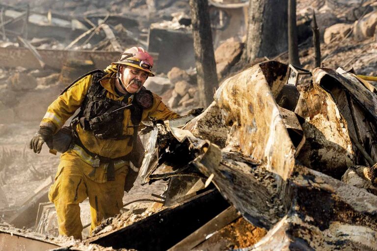 כבאי מחפש בהריסות בית מגורים נייד במתחם 'קאש קריק' בקליפורניה. שריפה שפרצה באזור באוגוסט הרסה עשרות בתים. (צילום: (AP Photo/Noah Berger
