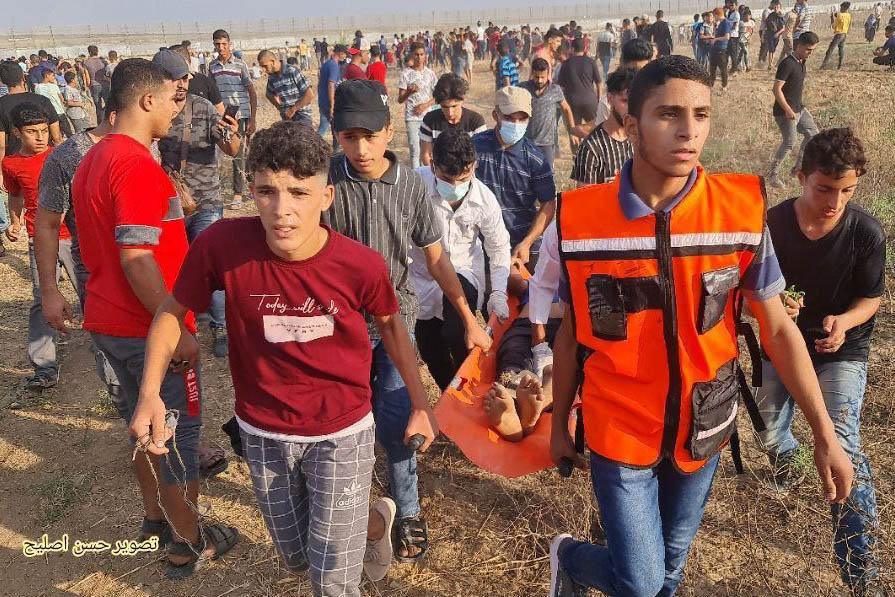 פלסטינים מפנים את הפצועים מאזור הגדר (צילום: גלובל טלגרם)