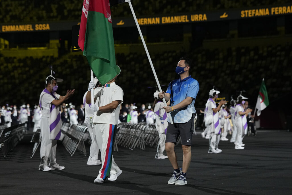 נציג האו"ם נושא את דגל אפגניסטן בטקס פתיחת המשחקים הפראלימפיים בטוקיו (AP Photo/Shuji Kajiyama)
