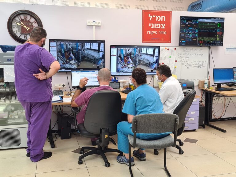 Staff members in the COVID-19 intensive care unit review the patients' conditions. (Photo: Dafna Eisbruch)