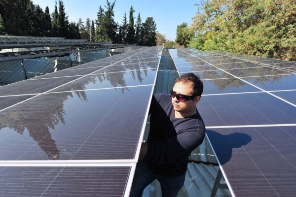 התקנת פאנלים סולאריים על גג בגדרה (ChameleonsEye / Shutterstock.com)