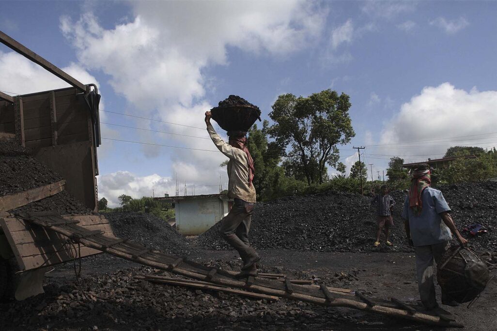 עובדים בהודו מעמיסים פחם על משאית באתר ייצור מקומי, ארכיון. (צילום: AP Photo/Anupam Nath)