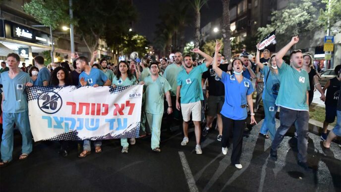Medical interns demonstrate for better work conditions in Tel Aviv. The sign reads: "We will not give up until shifts are shortened." (Photo: Tomer Neuberg / Flash90)