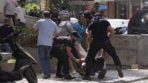 מפגינים שיעים מפנים פצוע בחילופי הירי ברחובות ביירות. (צילום: AP Photo/Hassan Ammar)