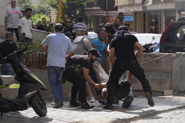 מפגינים שיעים מפנים פצוע בחילופי הירי ברחובות ביירות. (צילום: AP Photo/Hassan Ammar)