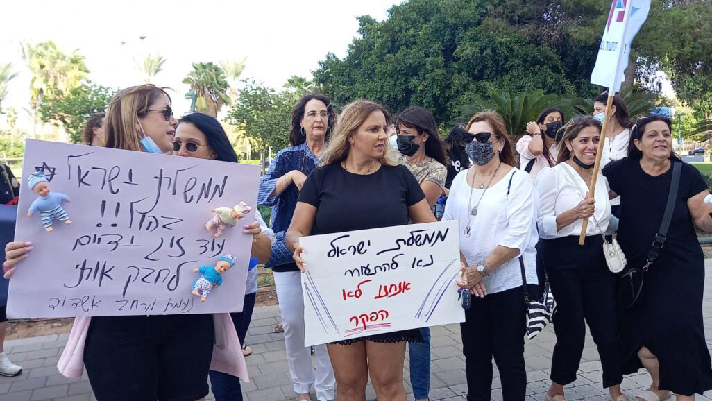 Daycare workers demonstrate in front of the home of Economy Minister Orna Barbivai, with signs calling on the government to wake up. (Photo: Daycare Struggle Headquarters)