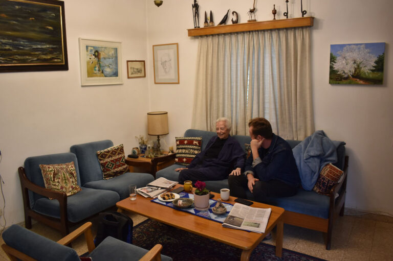 In Rachel's apartment on Kibbutz Menara with her grandson. “On Saturday night ,we sat here at home and watched the rally on television. I told Rafi, ‘Look how lovely, how successful the rally is.’ And then they said: ‘Breaking news.’” (Photo: Uriel Levy)