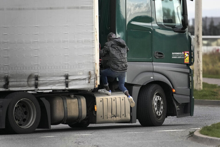 מהגר מנסה להסתתר בין תא המטען לתא הנהג. גם אחרי שהצליח לעלות למשאית, נקרים בדרכו אתגרים רבים (AP Photo/Christophe Ena)