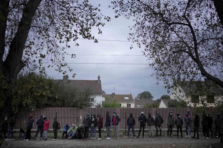מהגרים בתור למזון במחנה בקאלה. המשטרה פושטת כל בוקר, עוצרת, מרססת בגז מדמיע ומחרימה רכוש (AP Photo/Christophe Ena)