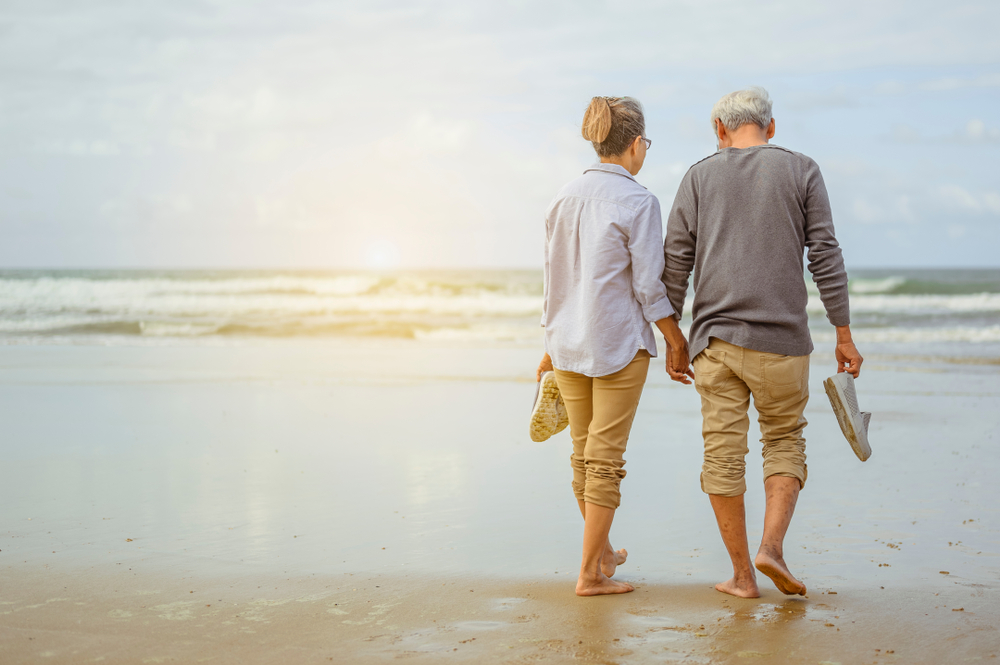 Senior,Couple,Walking,On,The,Beach,Holding,Hands,At,Sunrise, קרדיט: Shutterstock.