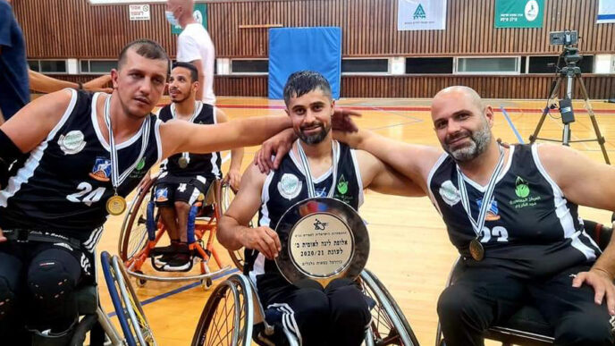 מימין לשמאל: יוסוף מנעא, מהראן חמדאן ומחמוד חמדאן, שחקני מג'ד אל-כרום בכדורסל בכיסאות גלגלים, עם צלחת האליפות (צילום: אלבום פרטי)