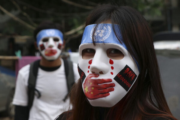 מפגינים במסכות נגד ההפיכה הצבאית במינאמר (צילום: AP Photo, File)